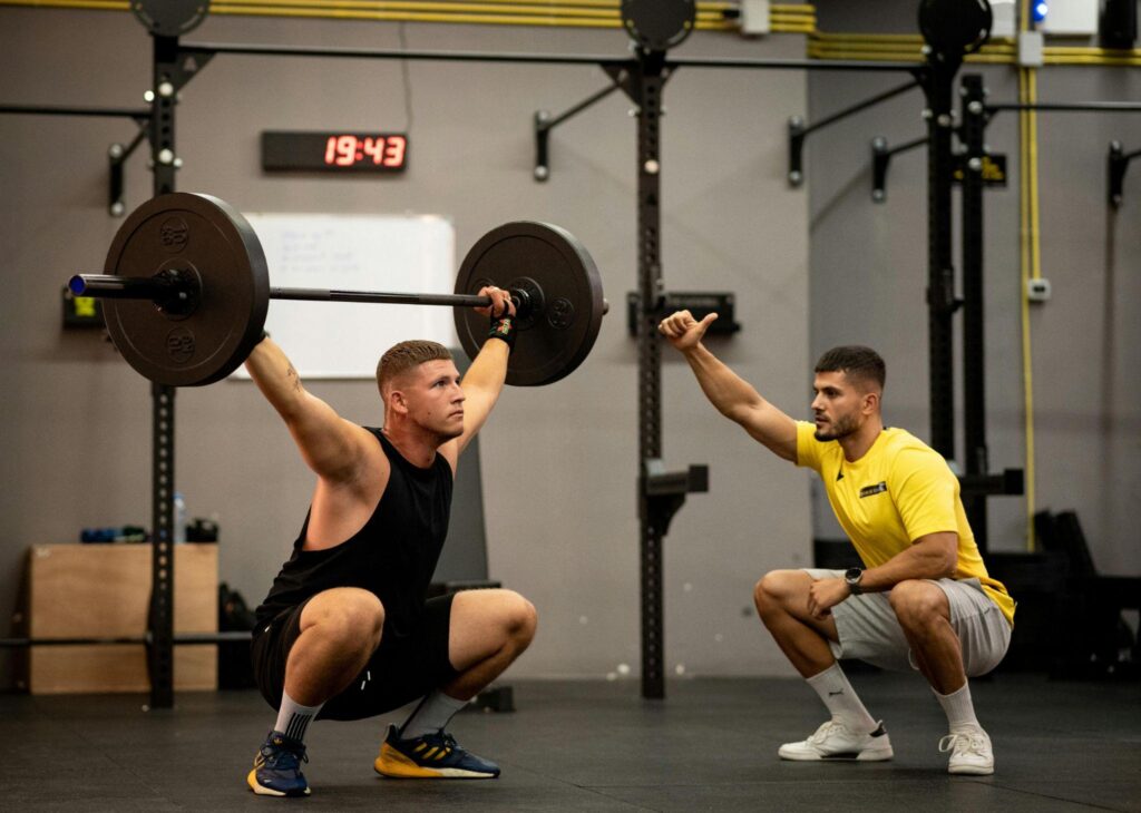 Personal trainer coaching a man during strength training